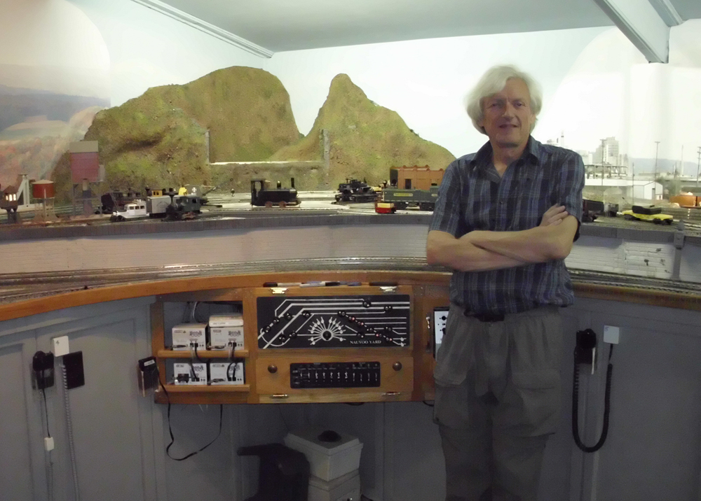 Man standing next to layout: O gauge layout made for operation