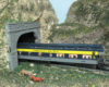blue and yellow model train enters tunnel