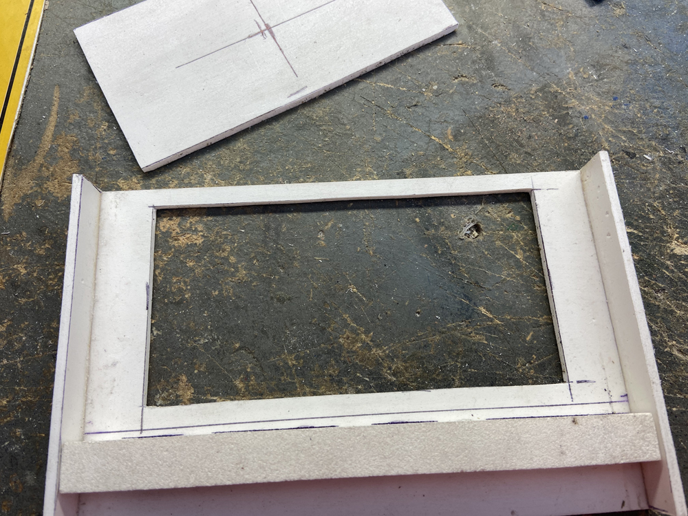 A styrene box with a rectangular hole cut out of it.