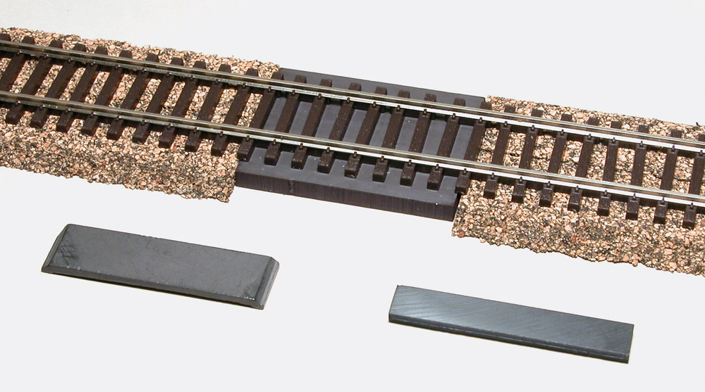 Photo with HO scale track, cork roadbed, and three magnets. 