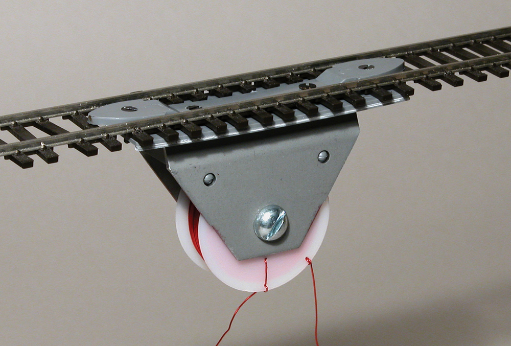 Color image of electromagnet mounted on piece of track. 