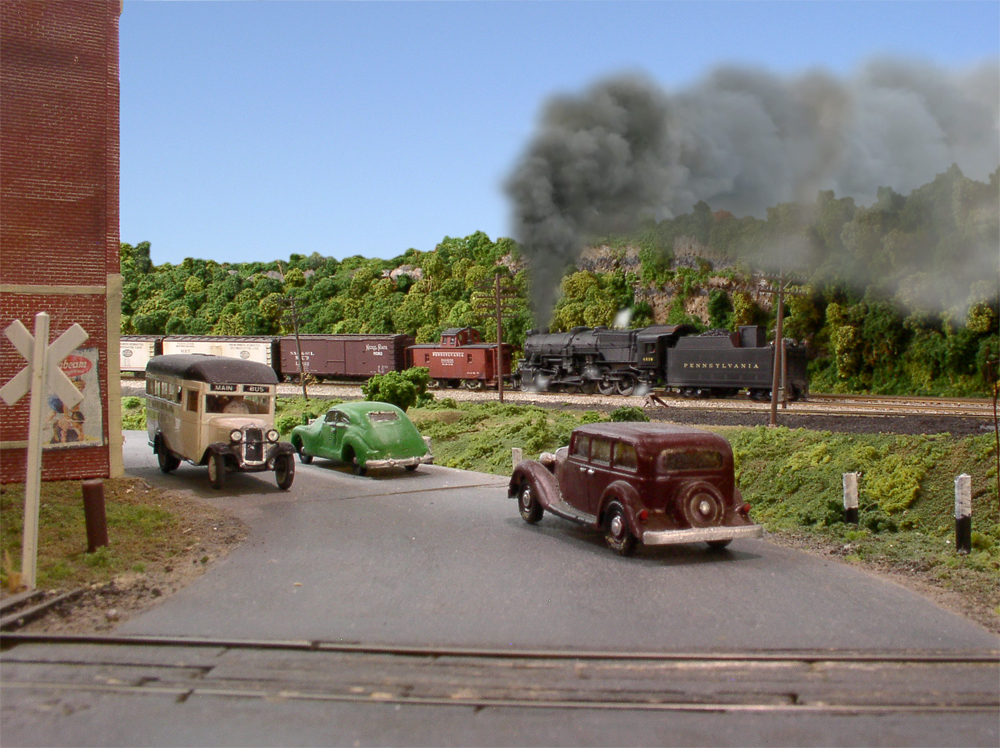 A model helper locomotive shoves a train out of a yard.