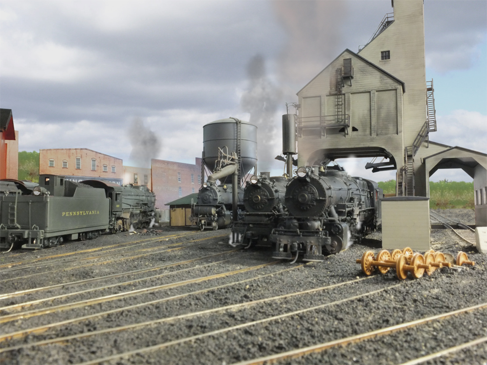 Model steam locomotives at an engine terminal.