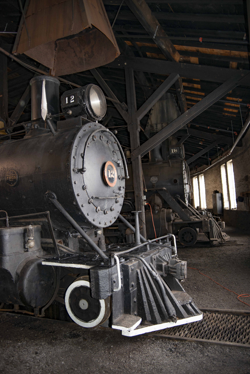 Two steam locomotives in a roundhouse