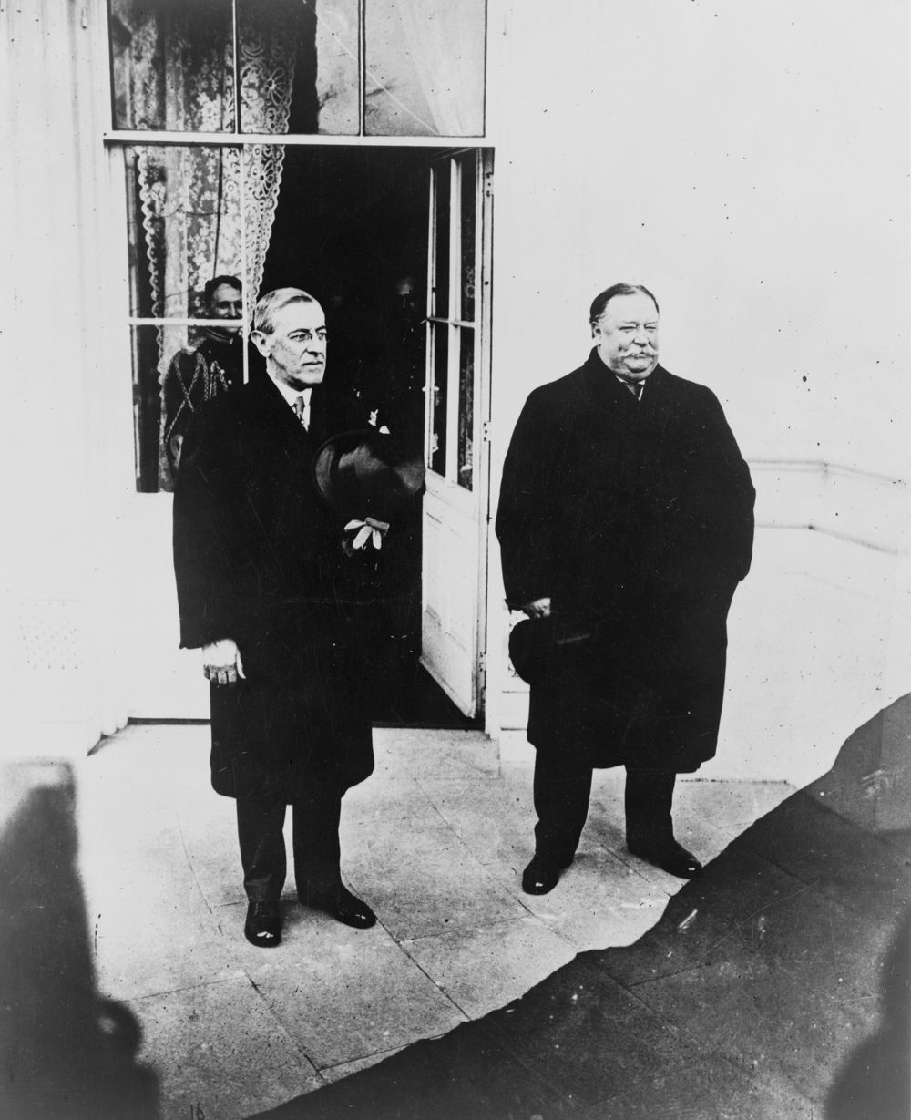 Two men standing outside a door.