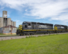 black locomotive with yellow on tracks