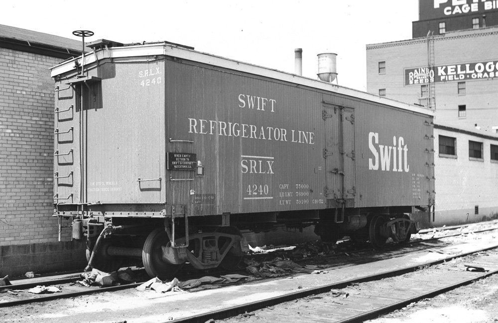 Black-and-white image of a wood refrigerator car with large “SWIFT” lettering on the side