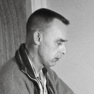 A black-and-white photo of a man with a crew cut seen in profile