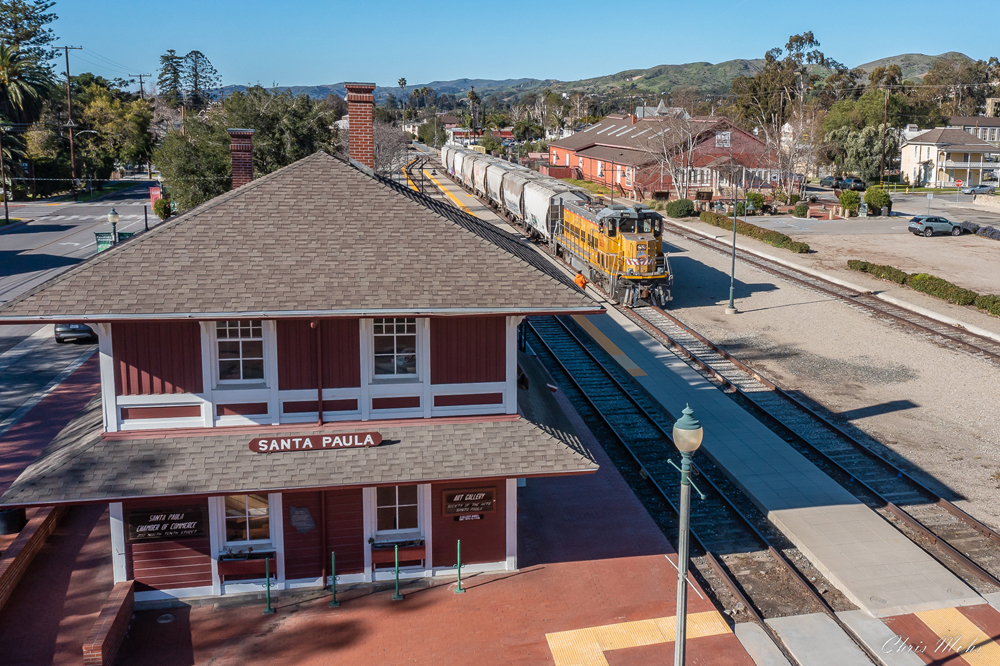 view looking down on red station with train in background