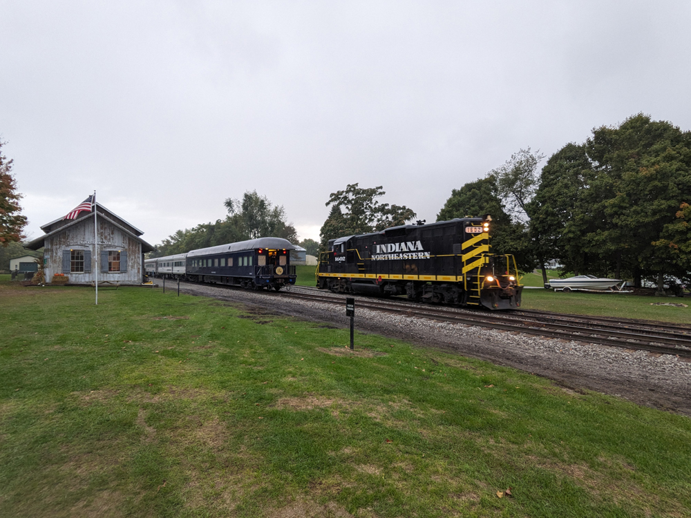 A diesel locomotive runs around a passenger train.