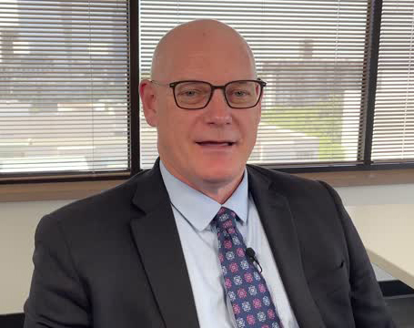 Man with glasses in coat and tie in office 