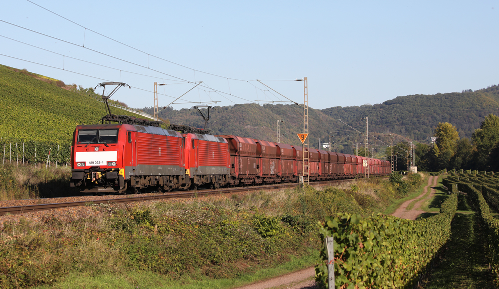 Two red electric locomotives with ore train