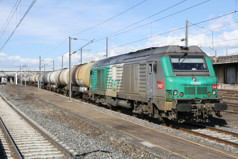Green and gray diesel lcomotive with tank cars