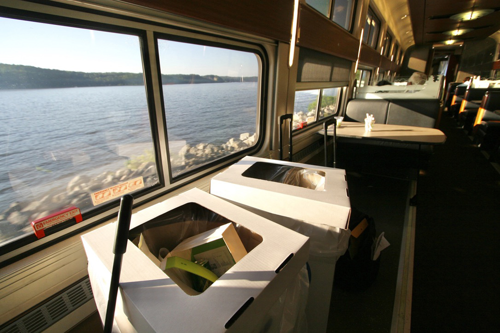 Cardboard trash boxes next to a window in dining car
