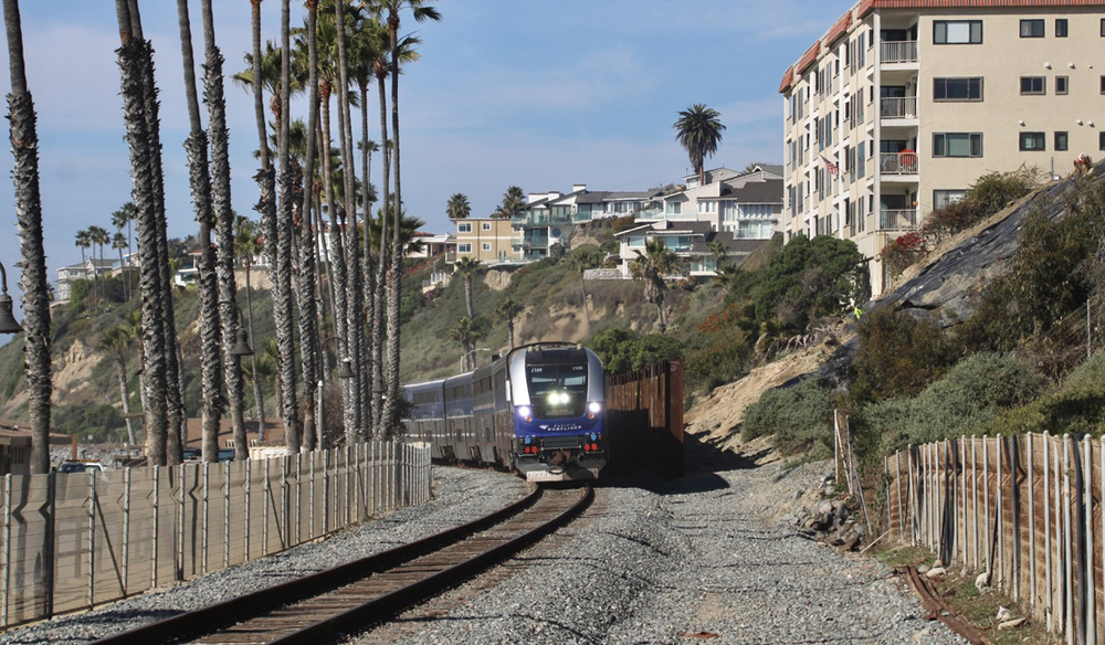 Train passing retaining wall in beach area