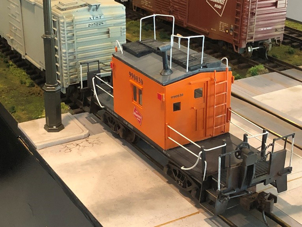 black and orange caboose on model track
