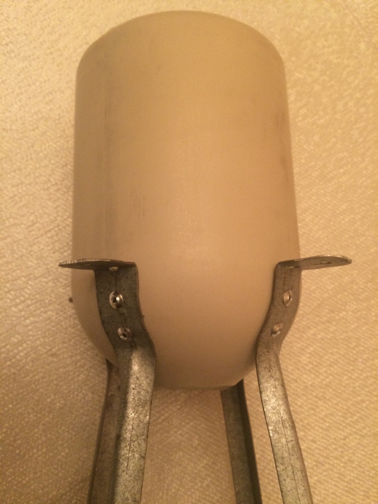 tan plastic jug with metal legs attached at bottom