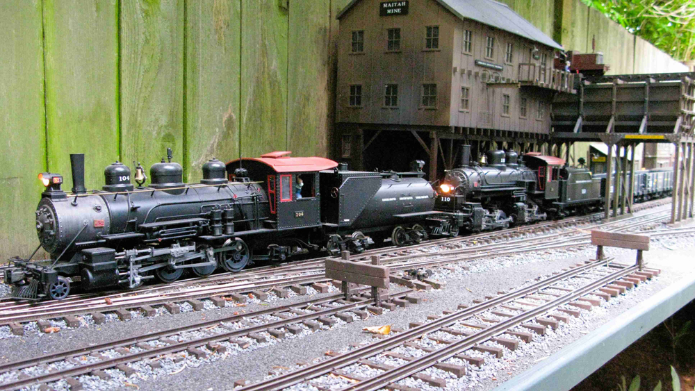 Locomotive next to fence on garden railway