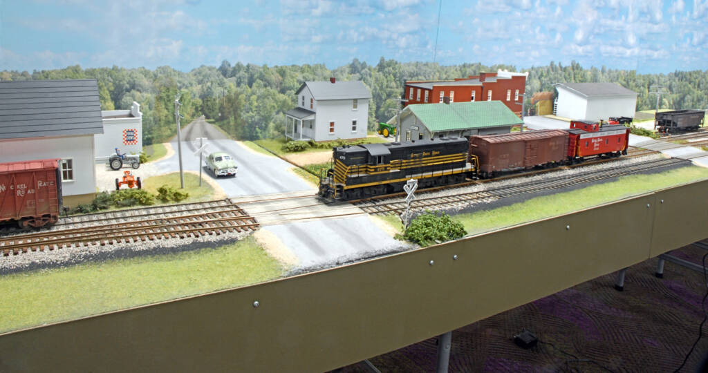 Color image of O scale layout with photo backdrop.