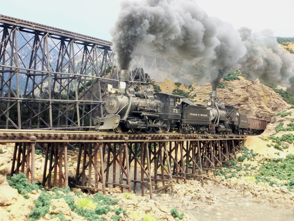 model steam locomotive crosses trestle