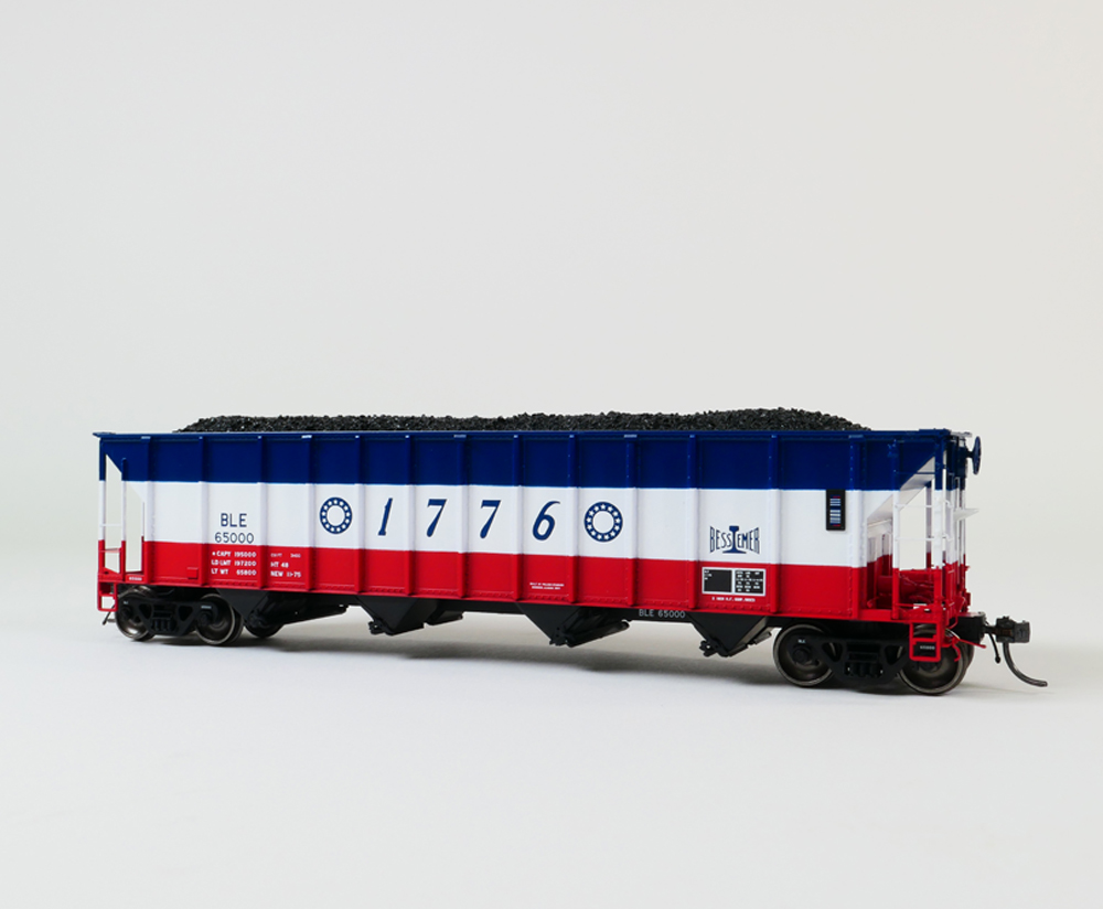 A model coal hopper car in a red, white and blue paint scheme