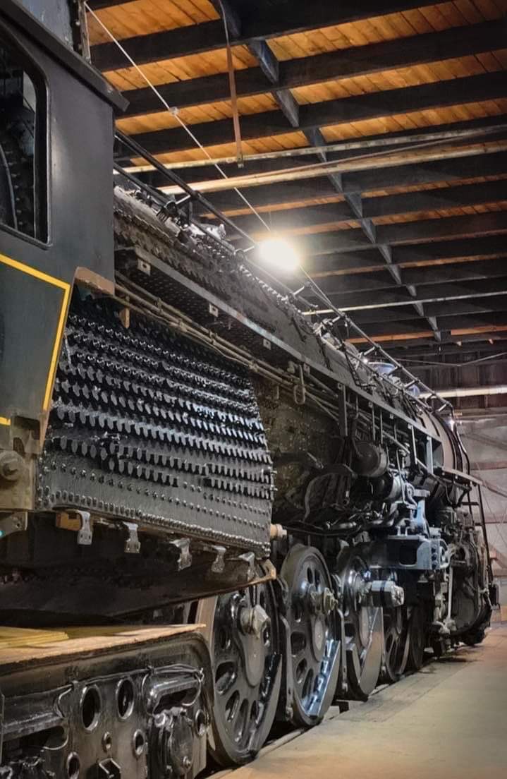 View of steam locomotive from beside cab looking forward