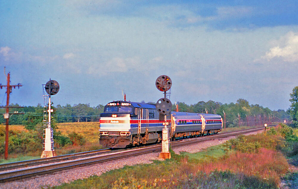 Amtrak train in sunlit landscape on track