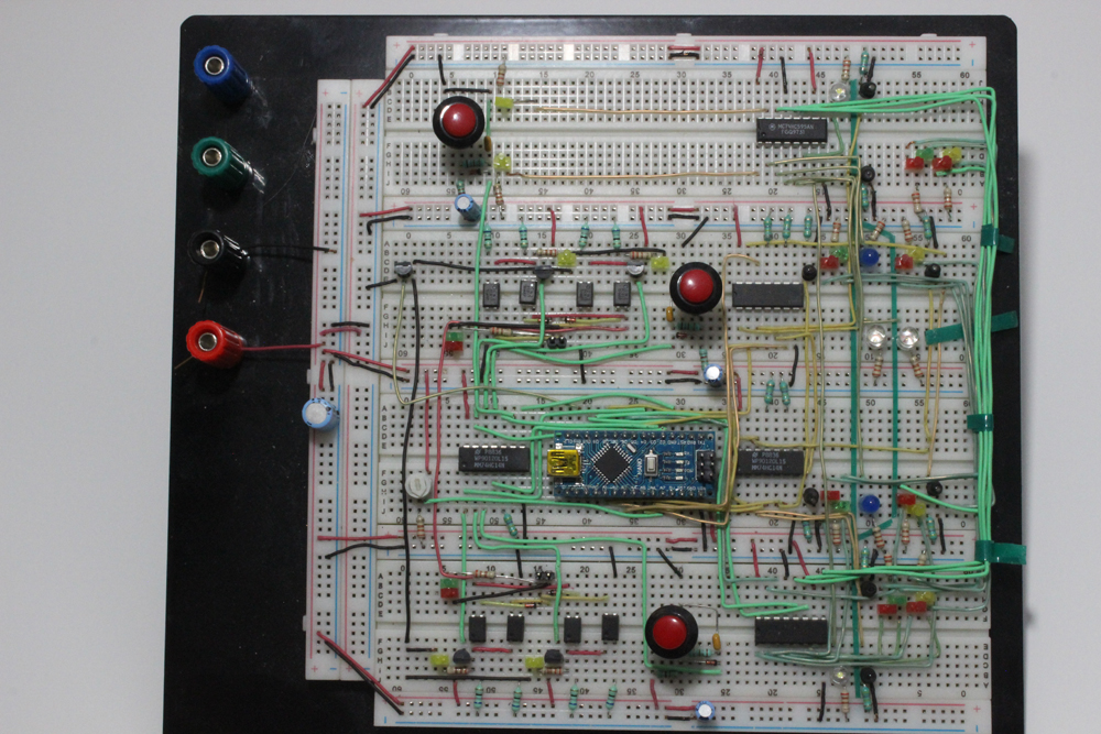 A white electric circuit breadboard with wires, controllers, sensors, and LEDs on it