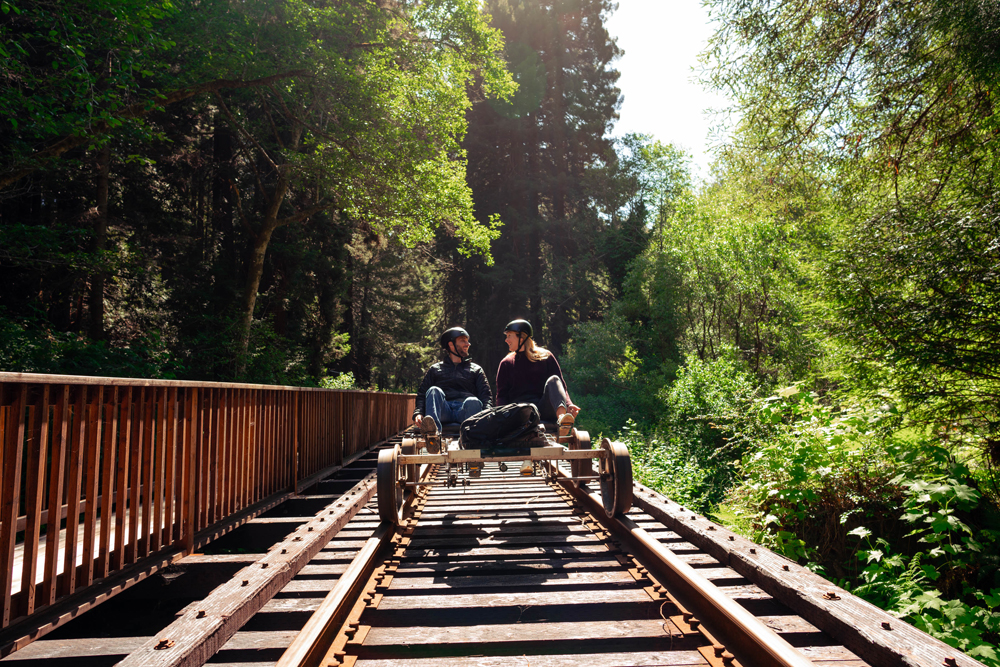 a man and woman on a railbike on tracks