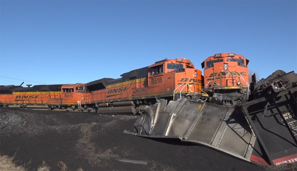 Derailed orange locomotives and coal hoppers