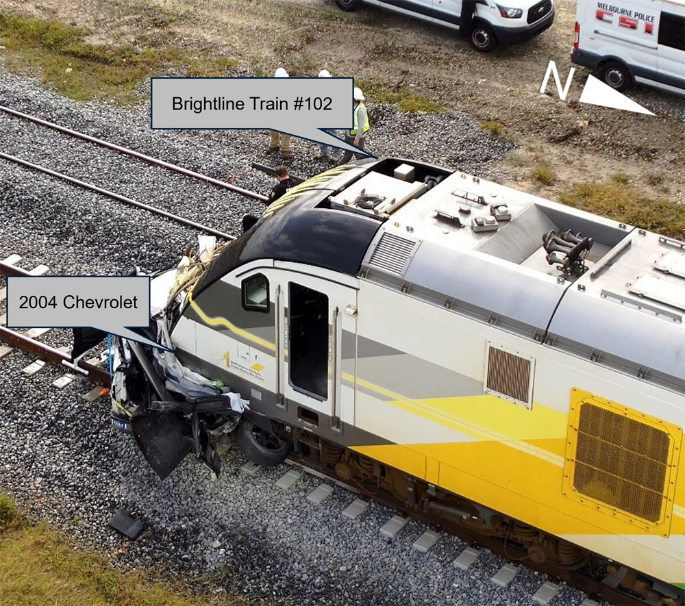 Overhead view of vehicle smashed by passenger train