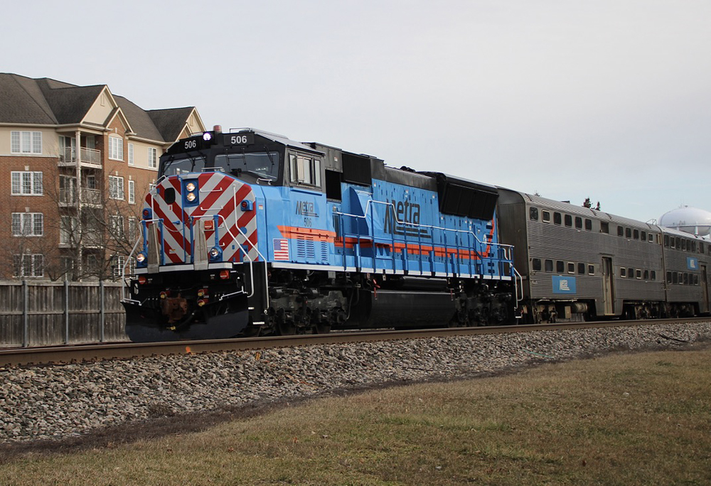 Blue diesel with red and white nose stripes on commuter train