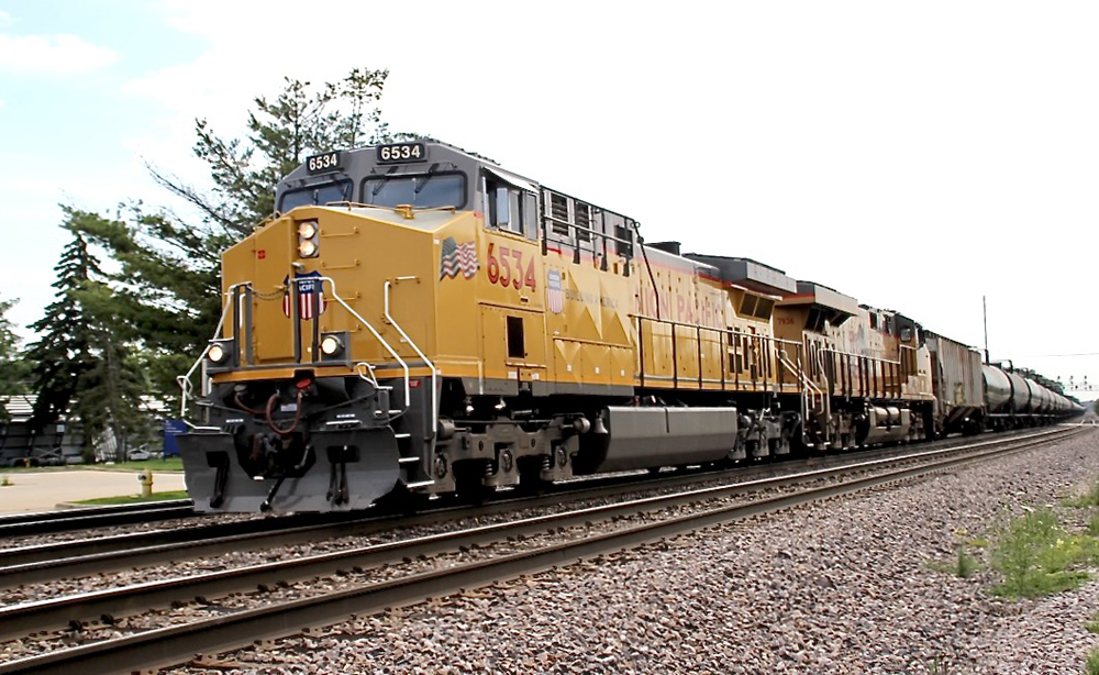 Yellow locomotives on train of tank cars