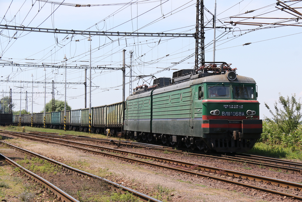 Green boxy electric locomotive pulling ore hoppers