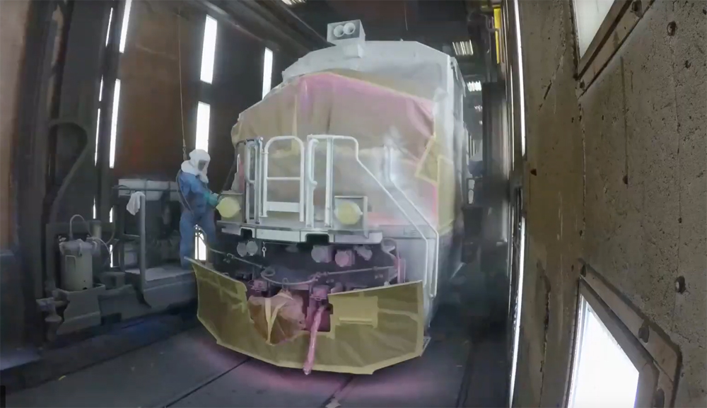 Locomotive masked for painting in booth at factory