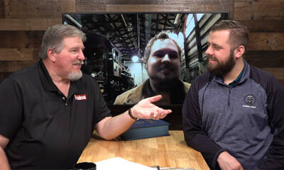 Two men at a table with another on a TV screen in an interview setting. Trains LIVE-Inspection Black River & Western No. 60