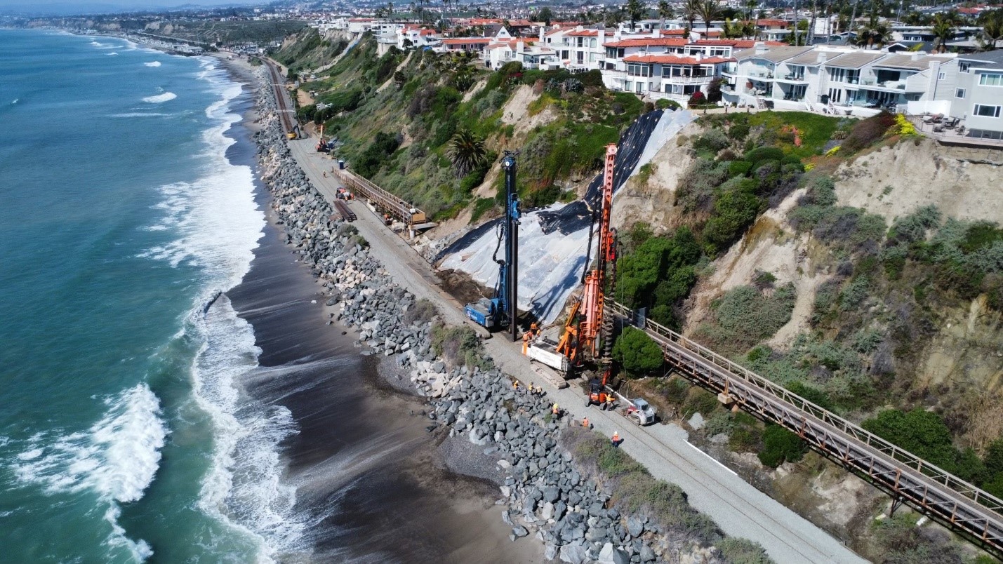 Drilling rigs on railroad track next to ocean