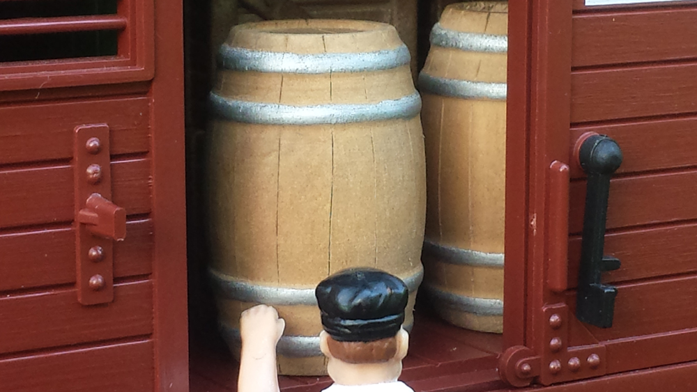 close up of wood barrels in boxcar with figure: inexpensive details from craft store toys
