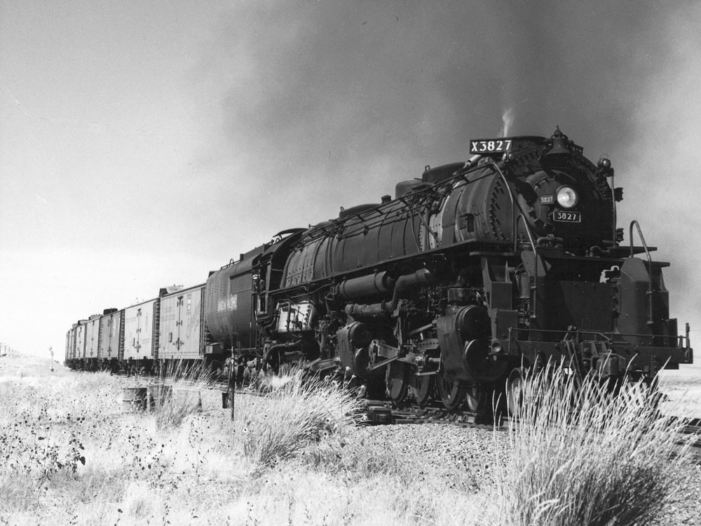 A black-and-white photo of a steam locomotive pulling a train of reefer cars