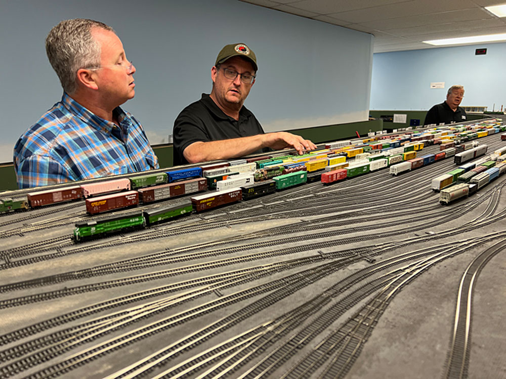 Three people operate on a large N scale layout