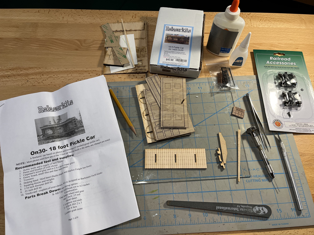 Color photo of kit components and tools on workbench.