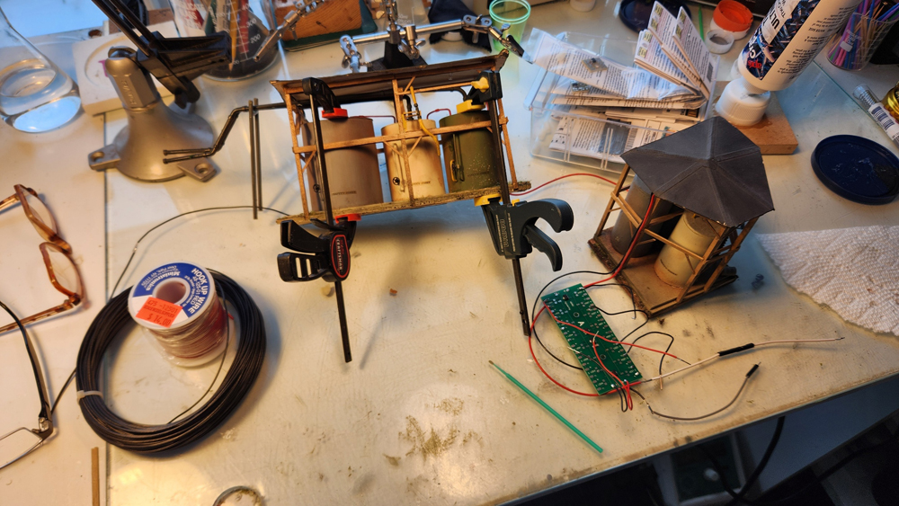 Color photo of structures, wires, and clamps on workbench.