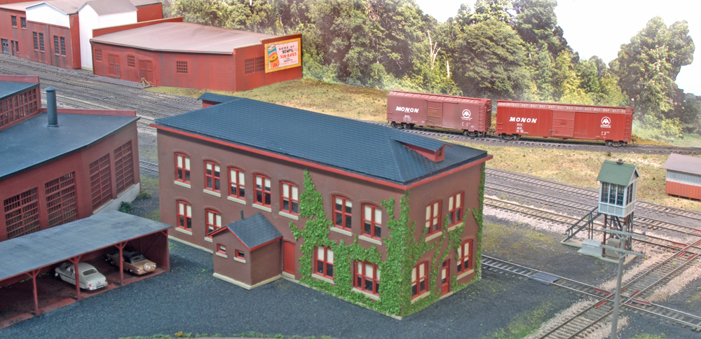 Color photo of two-story brick railroad office on model railroad.