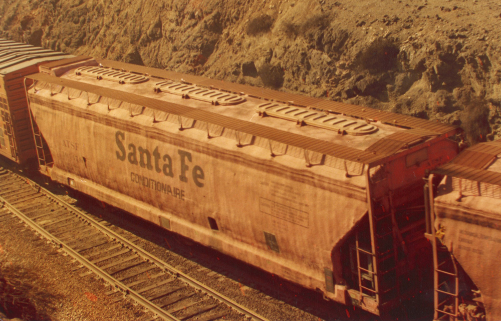 Color image showing top of covered hopper painted orange with black lettering.