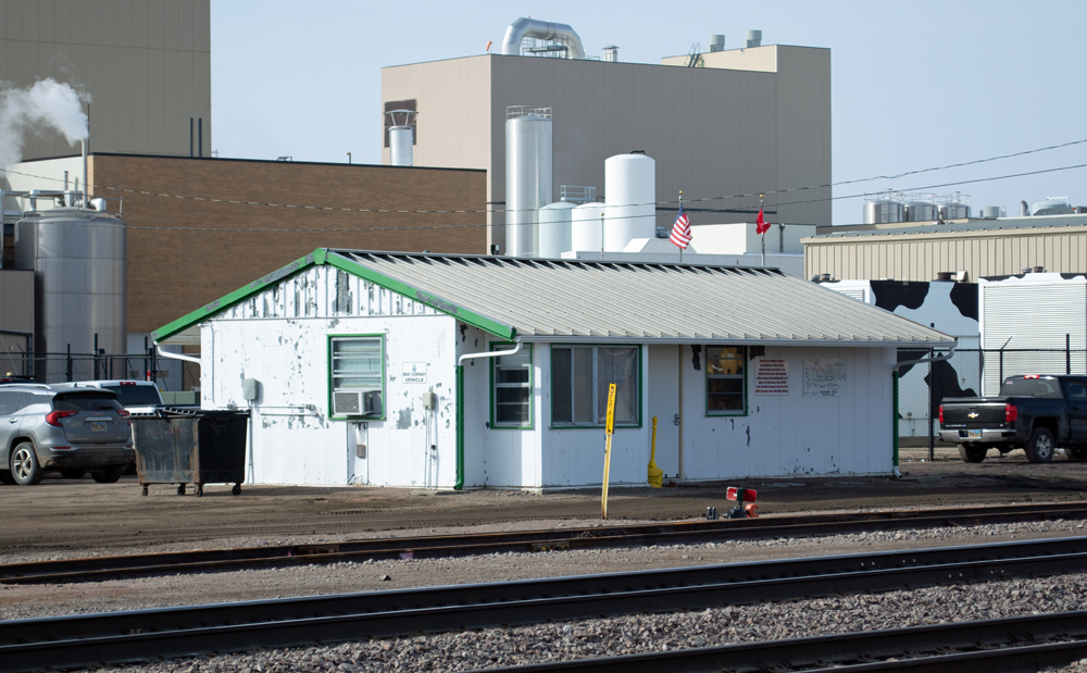 Color photo of yard office building near manufacturing plant. 