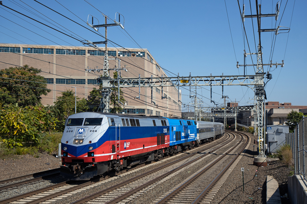 Metro train on tracks with building in background