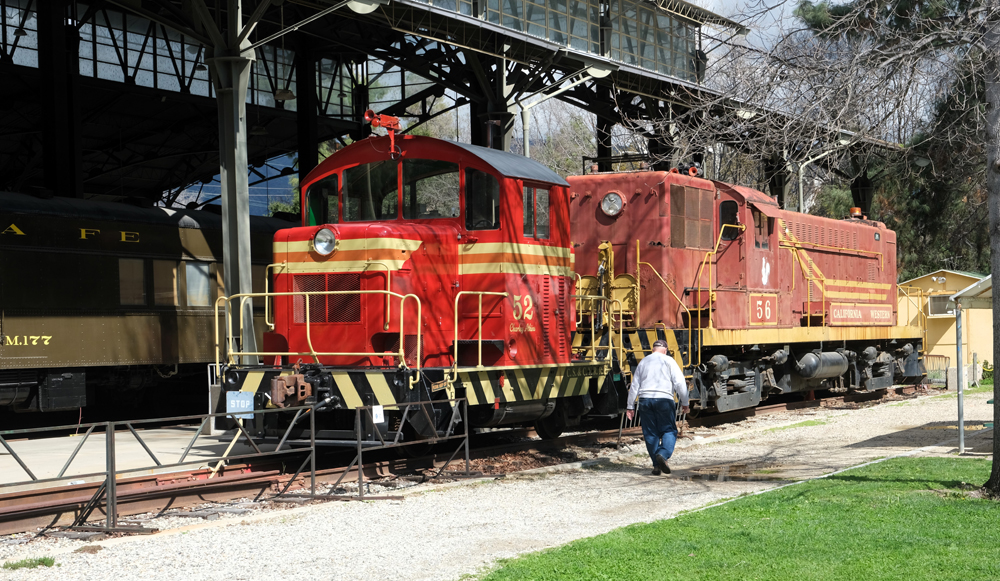red vintage locomotives with man walking towards them