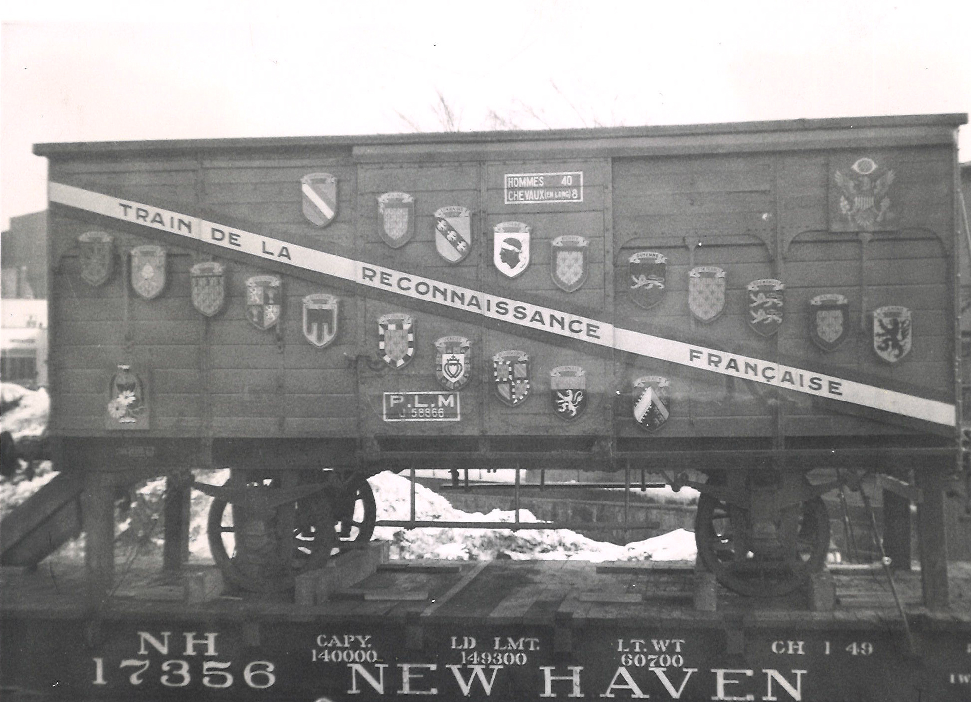 black and white photo of a French boxcar on a U.S. railroad flatcar. Five mind-blowing facts — The Merci Train.