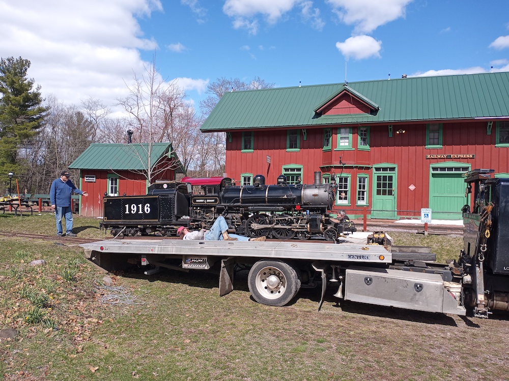 Little steam locomotive being unloaded from a trailer as part of a homecoming after departing from the Milwaukee County Zoo.