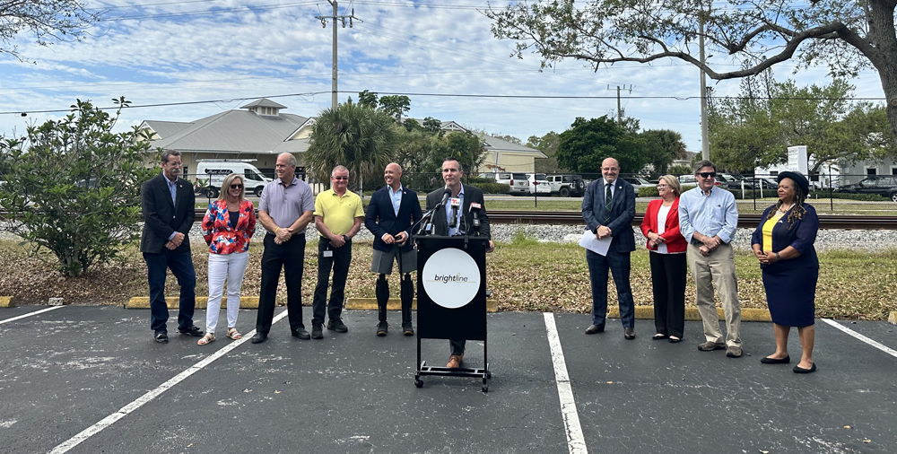 Ten people gathered at podium in parking lot